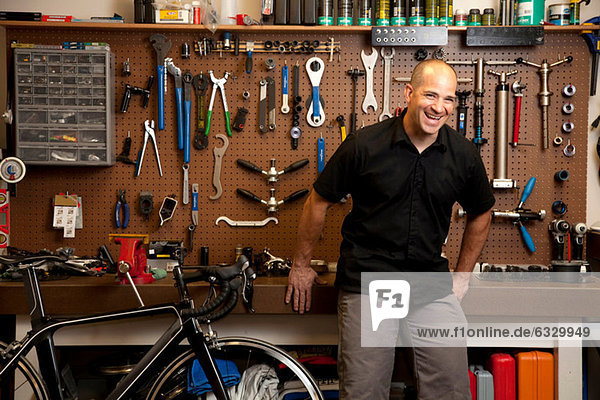 Man laughing in bicycle repair shop