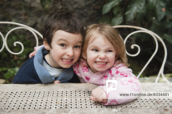 Young brother and sister smiling together outdoors  portrait
