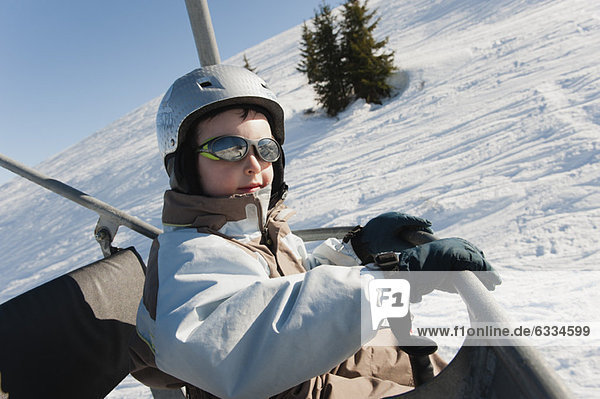 Boy riding ski lift at ski resort