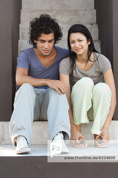 Young couple sitting together on steps