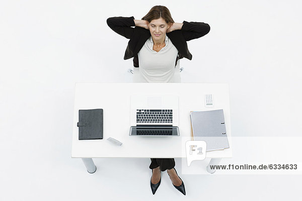 Geschäftsfrau entspannt am Schreibtisch mit geschlossenen Augen