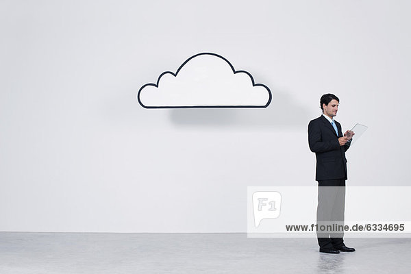 Geschäftsmann mit digitalem Tablett unter der Wolke  das Cloud Computing darstellt