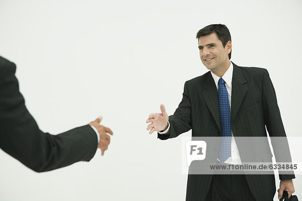 Businessman preparing to shake hands with colleague  cropped