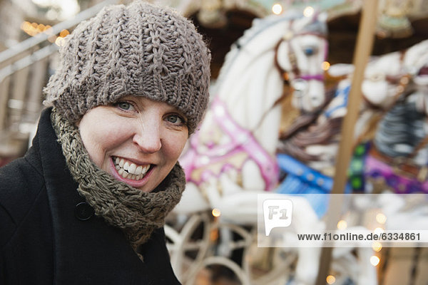 Woman in front of carousel  smiling  portrait