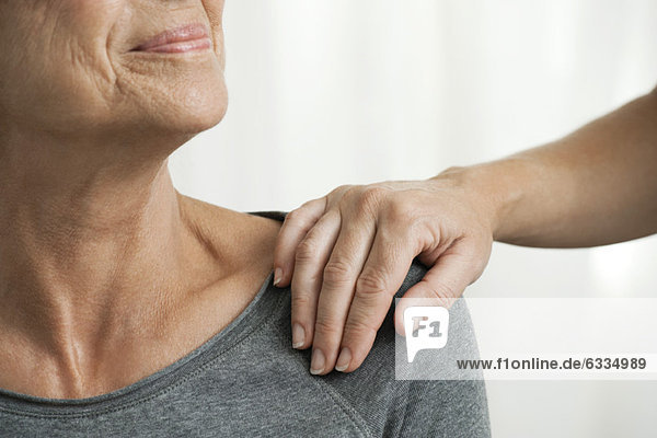 Beruhigende Hand auf der Schulter der Seniorin  abgeschnitten