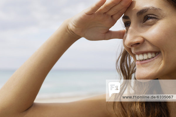 Woman at the beach  shading eyes to look at view