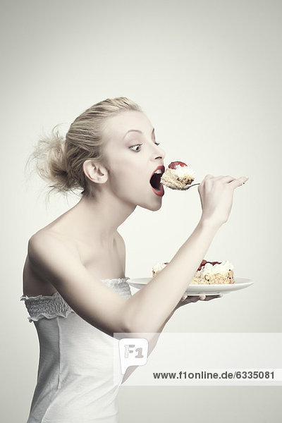 Young woman eating cake  side view  portrait