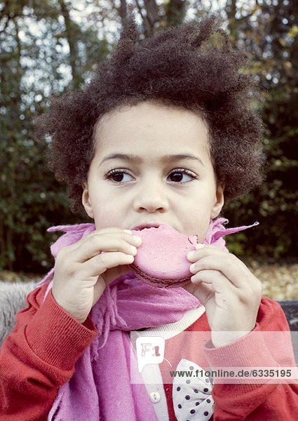 Kleines Mädchen isst Makrone  Portrait