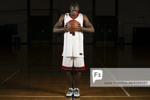 Basketball player holding basketball  portrait