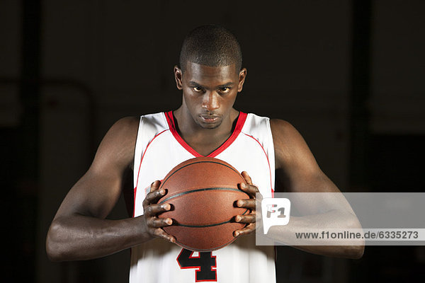 Basketball player holding basketball  portrait