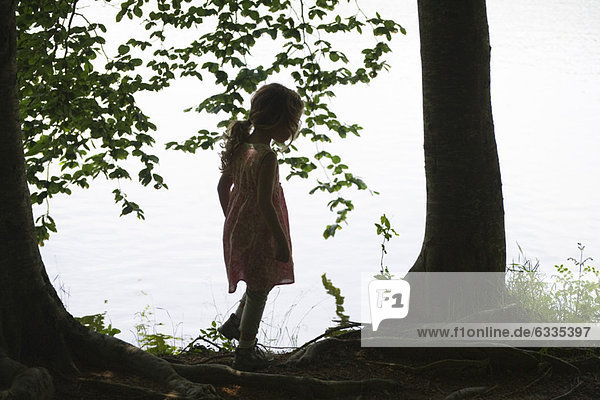 Silhouette des Mädchens am See stehend