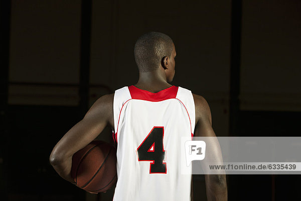 Basketball player holding basketball  rear view