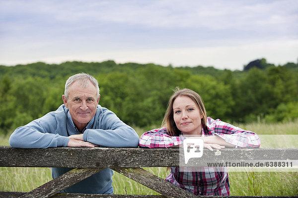 Vater und Tochter auf Holzzaun