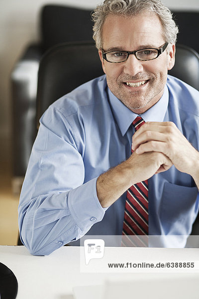 Smiling businessman sitting at desk