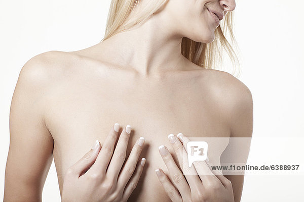 Frau bedeckt ihre nackten Brüste