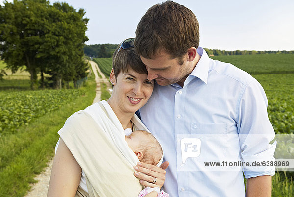 Couple holding infant on rural road