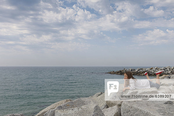 Girl relaxing on rocky beach