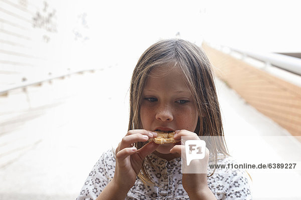 Girl eating cookie outdoors