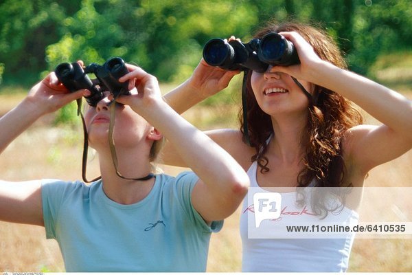 Jugendliche gucken durch Fernglas *** Local Caption ***