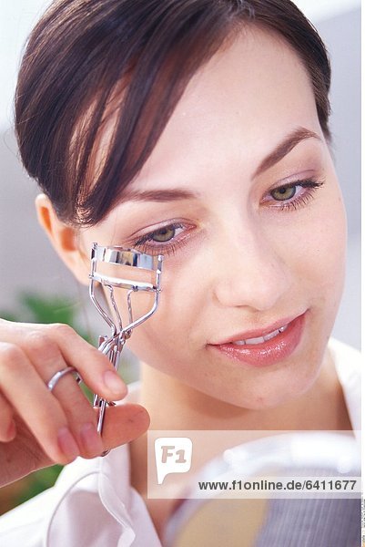 Junge Frau mit Wimpernzange