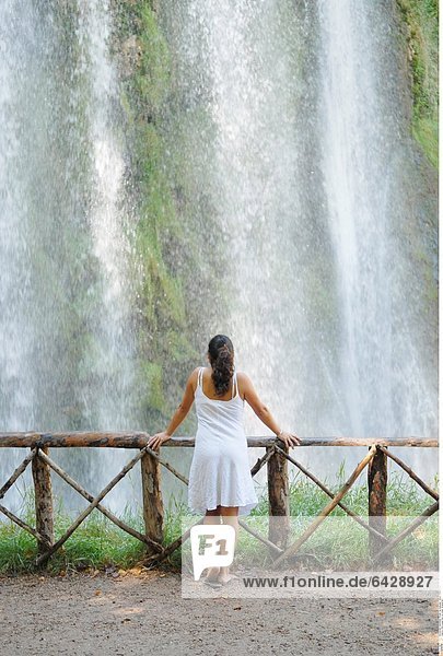 Eine junge Frau vor einem Wasserfall
