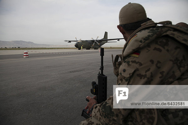 German soldier waiting at the NATO military airport in Kunduz in front of a Transall C-160 from the German Air Force or Luftwaffe  Kunduz  Afghanistan  Asia