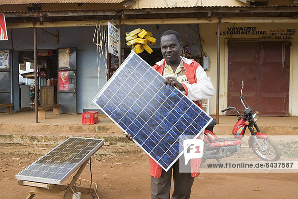 Mr. Tinkasimire  owner of an electrical shop  offering products like Premier Modul solar panels  Masindi  Uganda  Africa