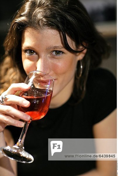 Junge Frau trinkt Wein