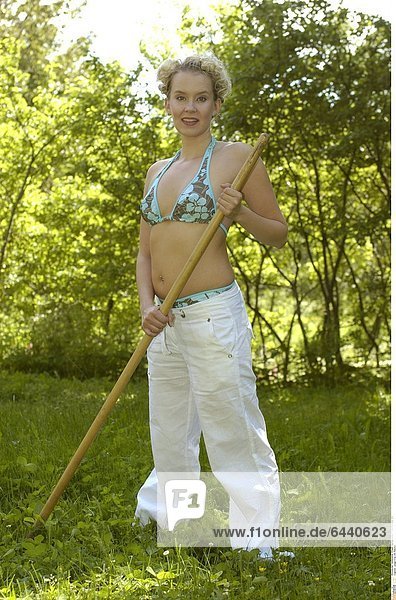 Junge Frau mit Rechen