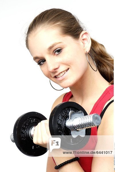 Junge Frau im roten Sporttop trainiert mit einer Kurzhantel. *** Local Caption ***