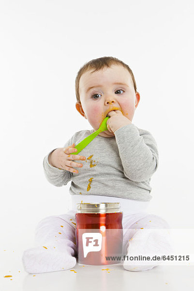 Ein Baby  das Nahrung aus einem Behälter isst.