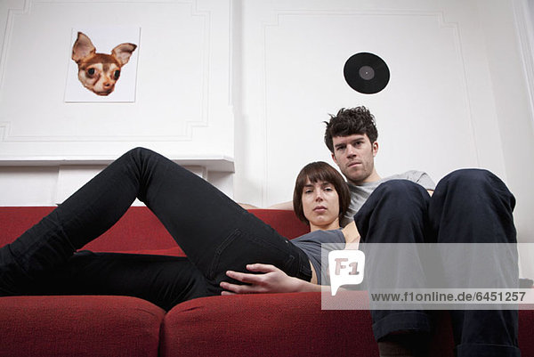 A young hip couple relaxing together on a couch