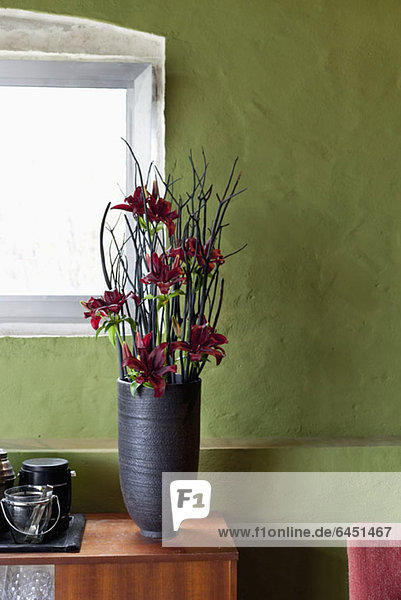Eine Vase mit Blumen auf einem Sideboard