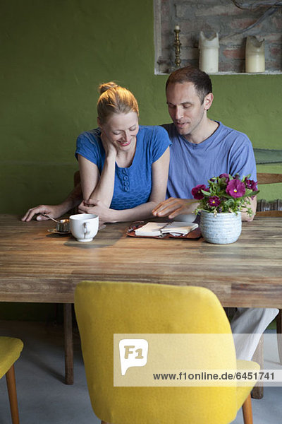 A man talking about his journal to his girlfriend at the dining table