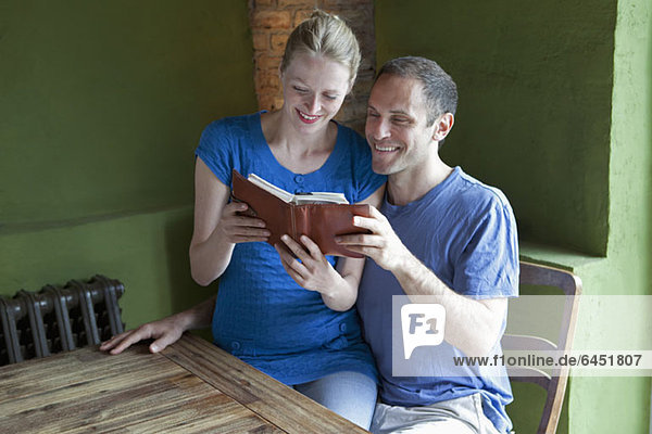 Ein Paar liest gemeinsam einen Terminplaner und lächelt