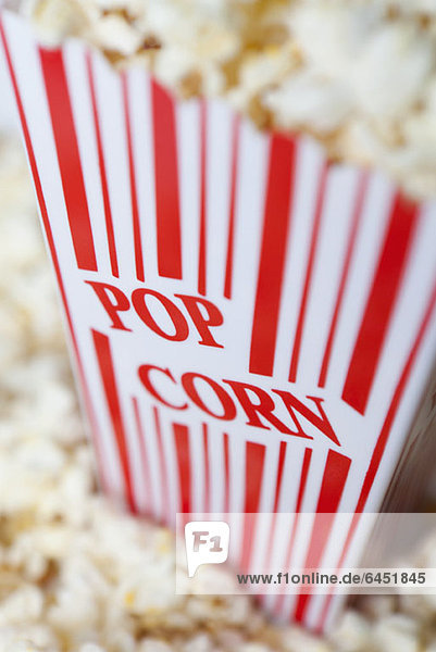 Detail eines rot gestreiften Popcorn-Kartons mit aufgedrucktem Popcorn