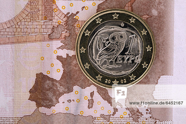 Detail einer Zehn-Euro-Banknote mit einer Ein-Euro-Münze darauf