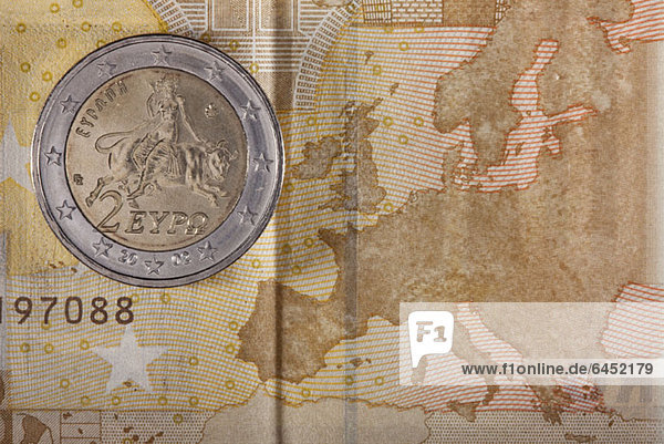 Detail einer Fünfzig-Euro-Banknote mit einer Zwei-Euro-Münze darauf
