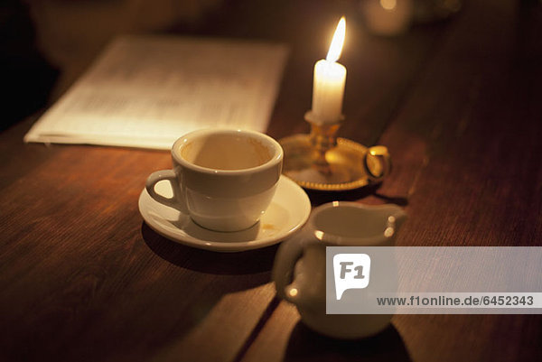 Leere Tasse Kaffee bei Kerzenlicht