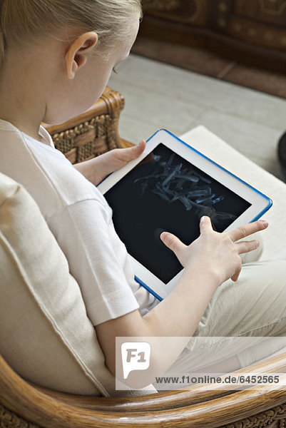 Ein Mädchen sitzend mit einem digitalen Tablett