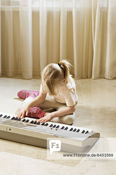 Ein Mädchen spielt ein elektronisches Keyboard