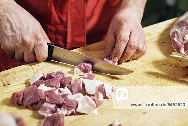Detail eines Mannes beim Hacken von Fleisch