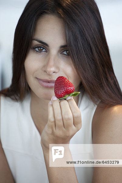 Elegant woman offering strawberry