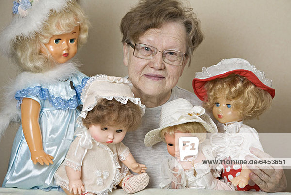 Eine ältere Frau mit ihrer Sammlung altmodischer Puppen