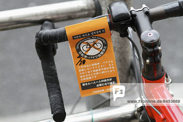 A 'No Standing'' Parkschein für Fahrräder in Englisch und Japanisch'.