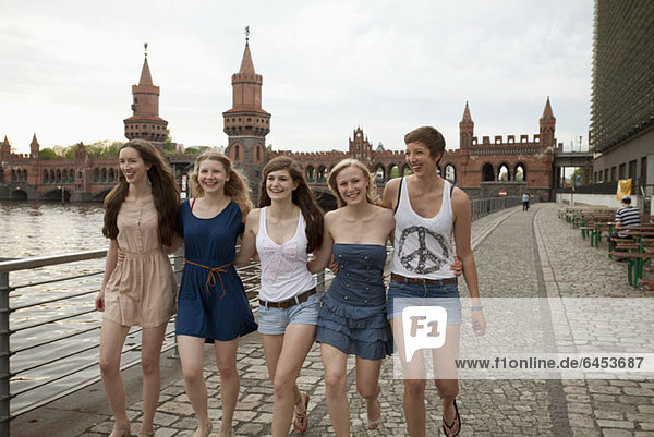 Five female friends walking side by side near the Oberbaumbruecke  Berlin  Germany
