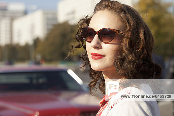 A pretty rockabilly woman standing near a vintage care  focus on woman