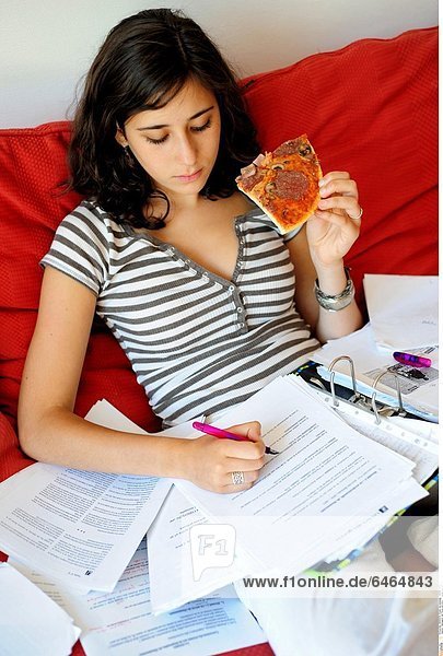 Teenagerin isst Pizza und lernt *** Local Caption ***