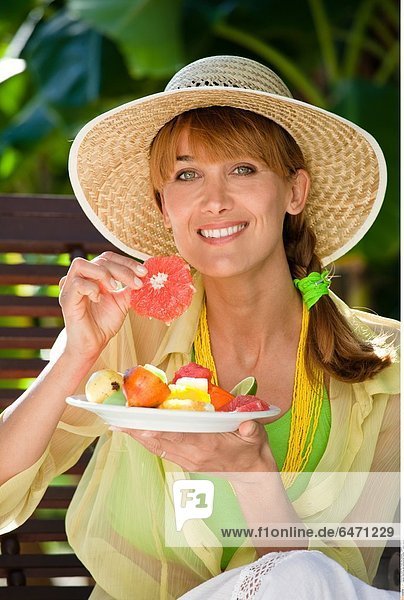 Eine Frau isst sommerliche Früchte *** Local Caption ***