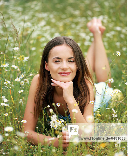 1228741 outdoor day summer people woman girl young 20-25 brunette long haired hair meadow field rest relax vacation smile smiling lie vertical